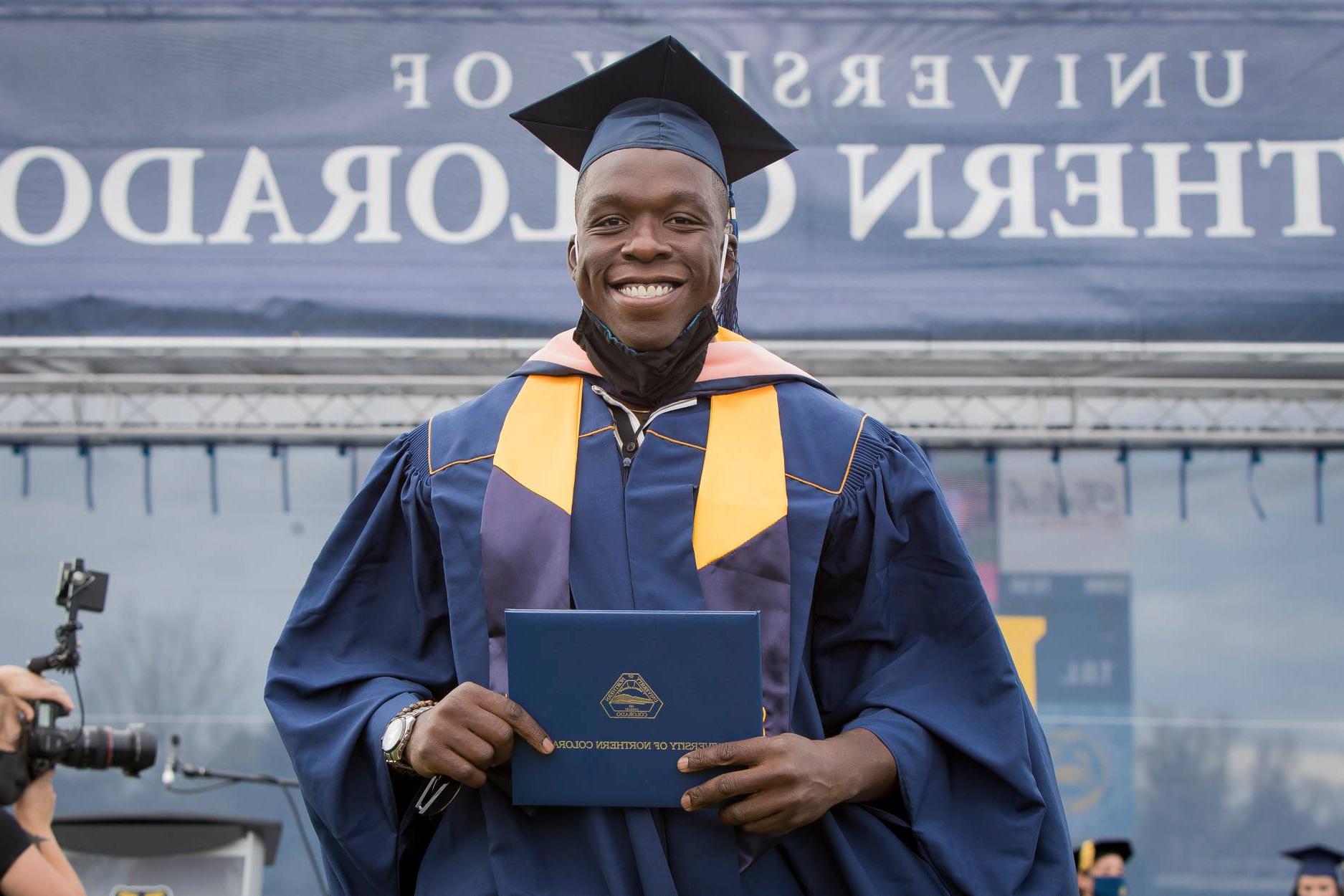 科罗拉多公共卫生学院的学生Fisayo Awolaja正在接受毕业证书. 最佳研究生院2023美国博天堂官方网站标志在图像的左上角. 